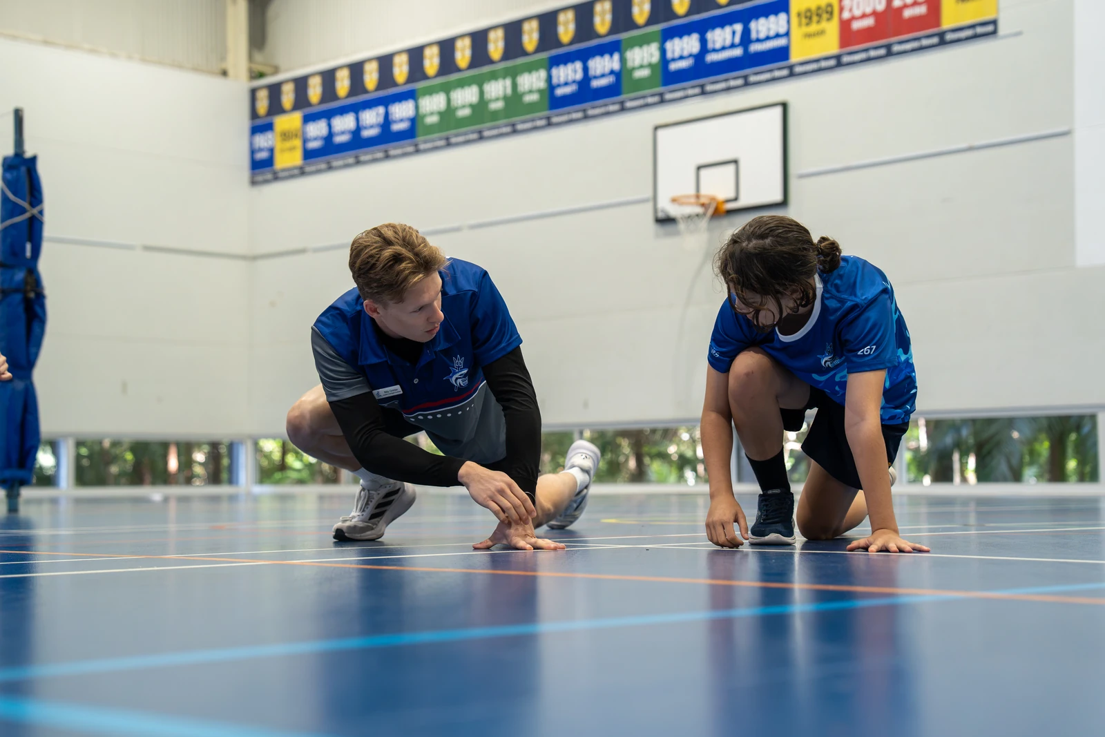 A Sharks Volleyball coach working one-to-one with an athlete on court