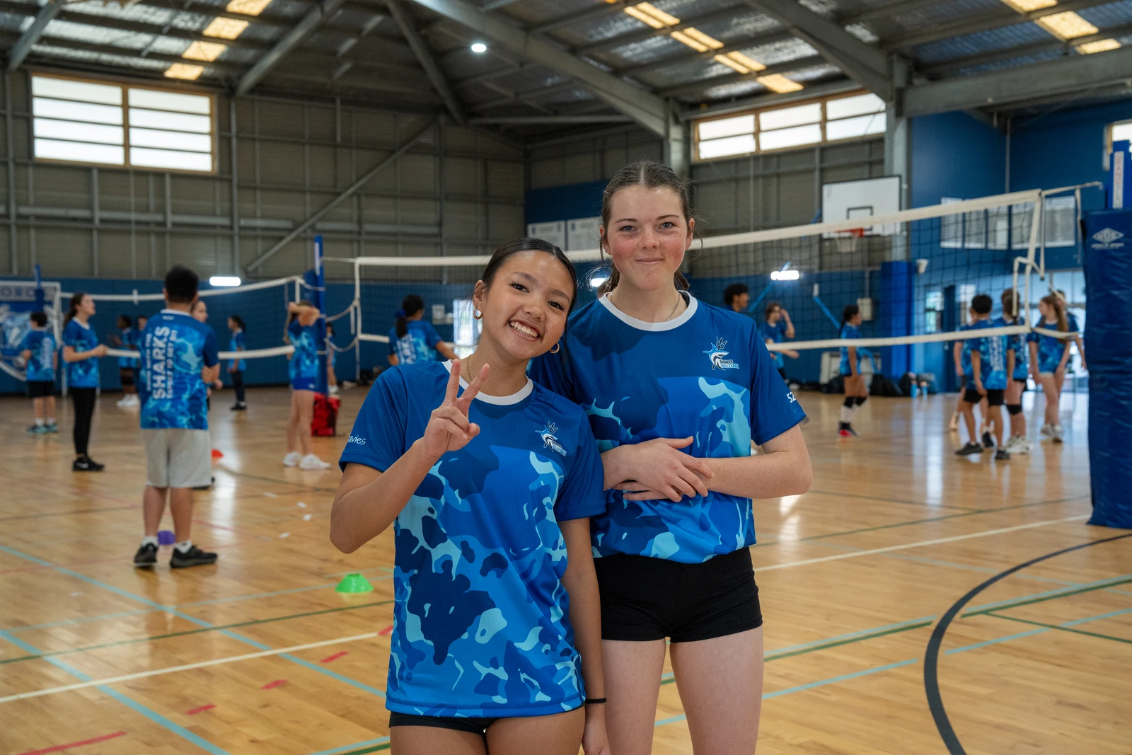 Two Sharks Volleyball athletes enjoying a social session together on court
