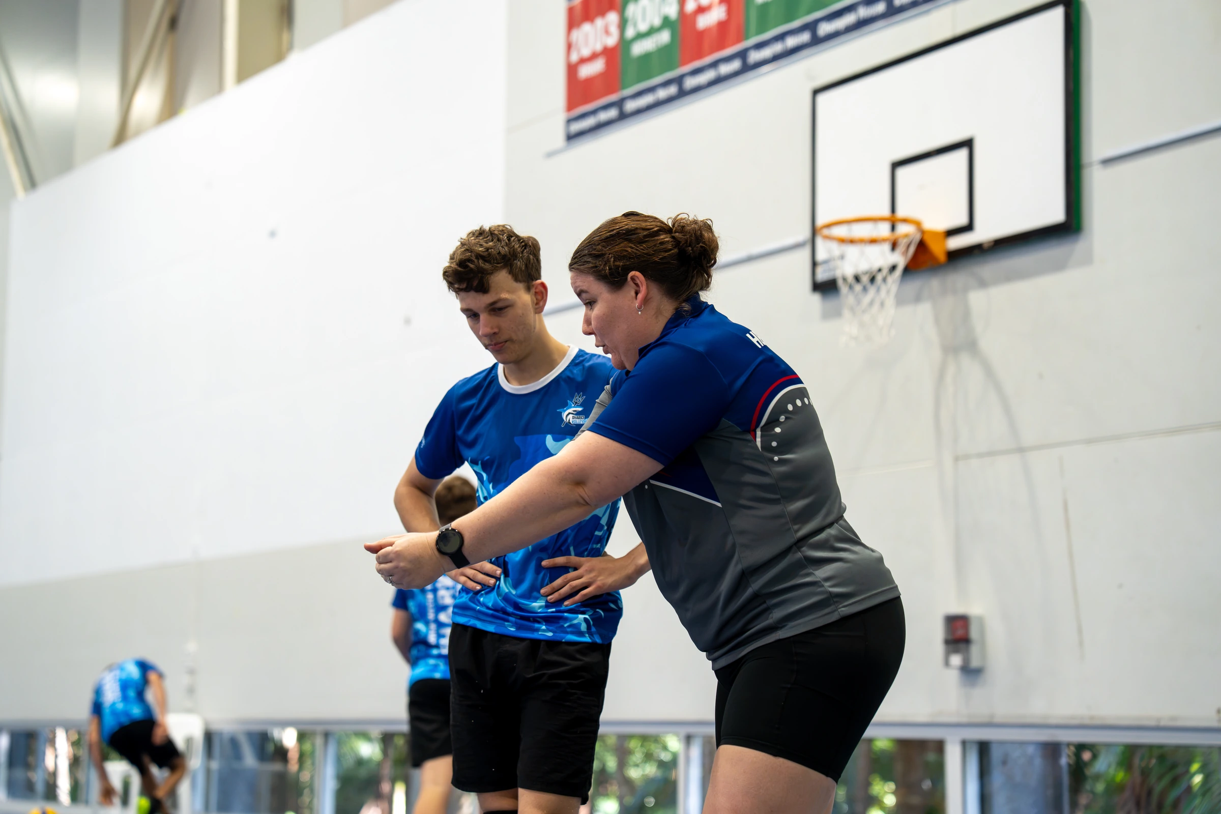 Sharks Volleyball coach demonstrating a technical movement to an athlete