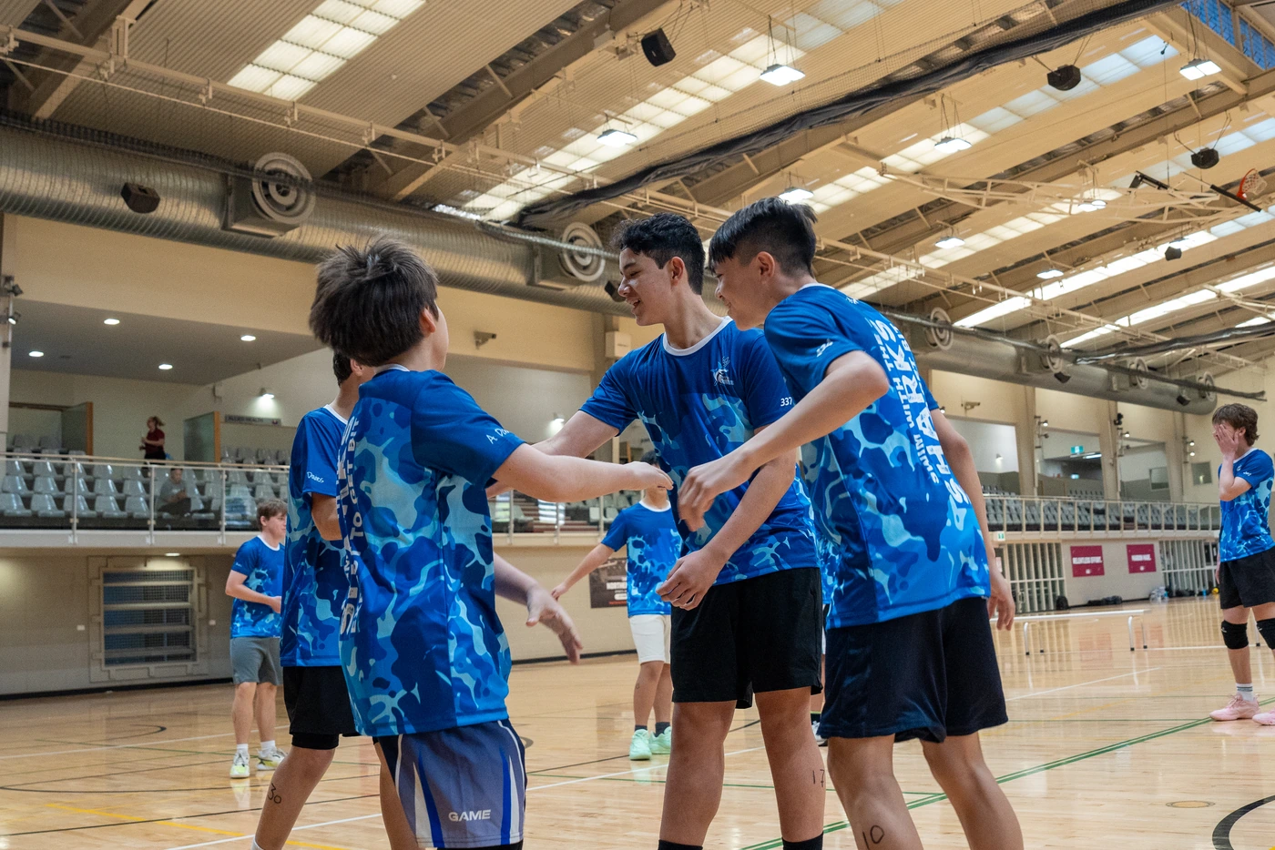 Sharks Camp athletes joining a team huddle at Holland Park